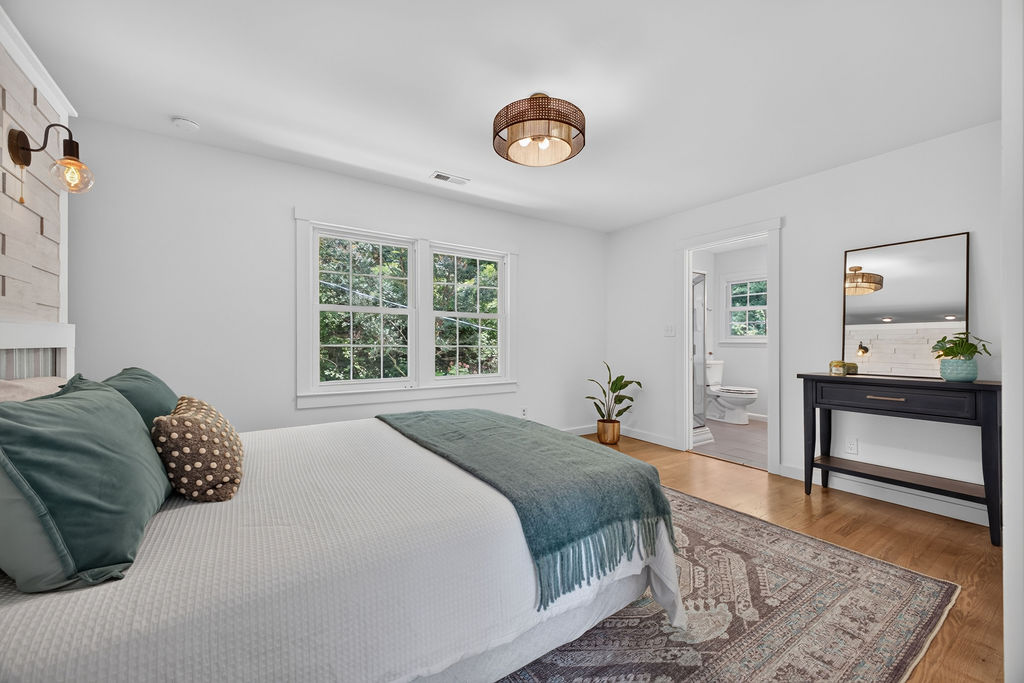 Primary bedroom with shiplap headboard wall and ensuite bath beyond